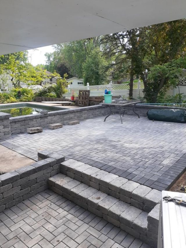 a patio with stairs and a table in the middle of it .