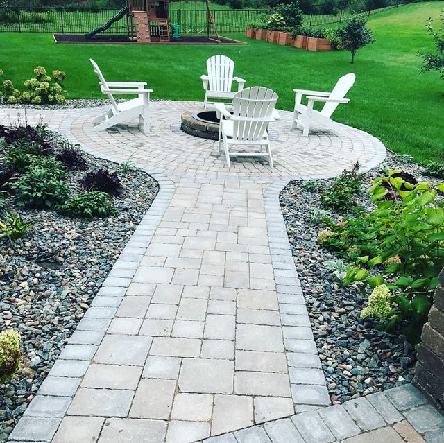 a patio with chairs and a fire pit in the middle