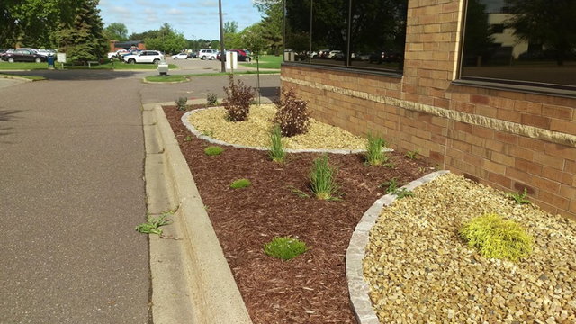 a brick building with a garden in front of it .