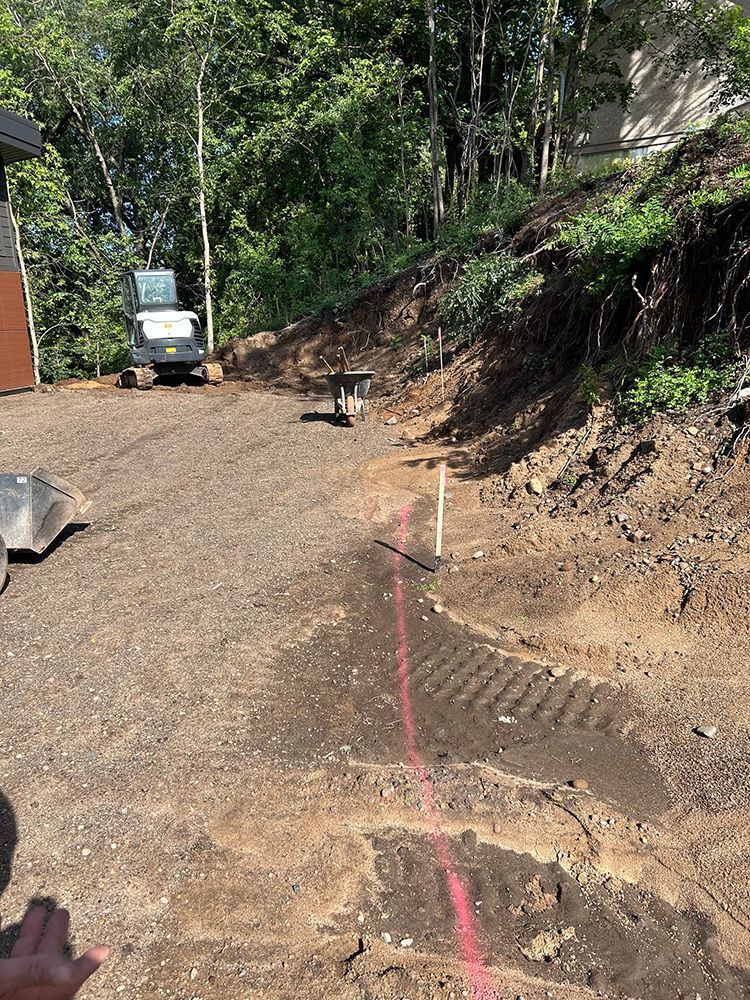 A person is standing in a dirt field with a red line in the dirt.