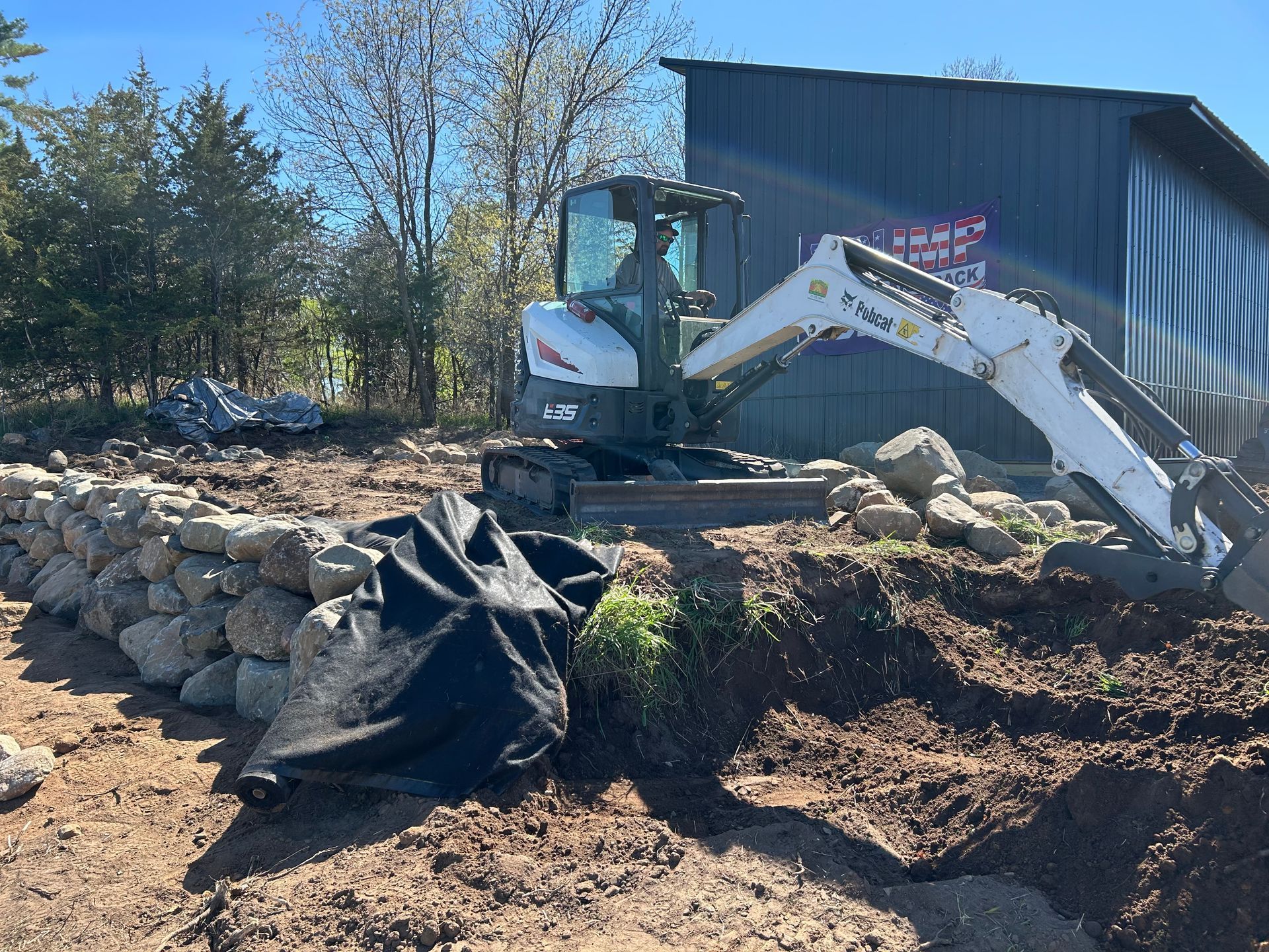 A bobcat excavator is digging a hole in the dirt