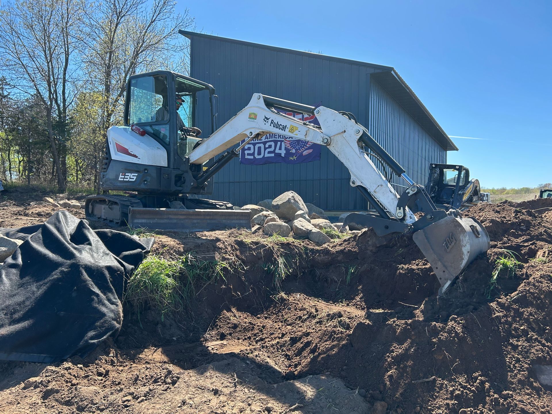 A bulldozer is digging a hole in the dirt in front of a building.