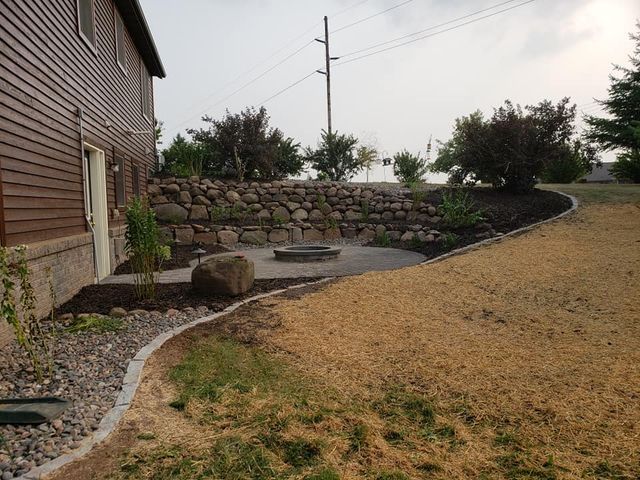 there is a fire pit in the backyard of a house .