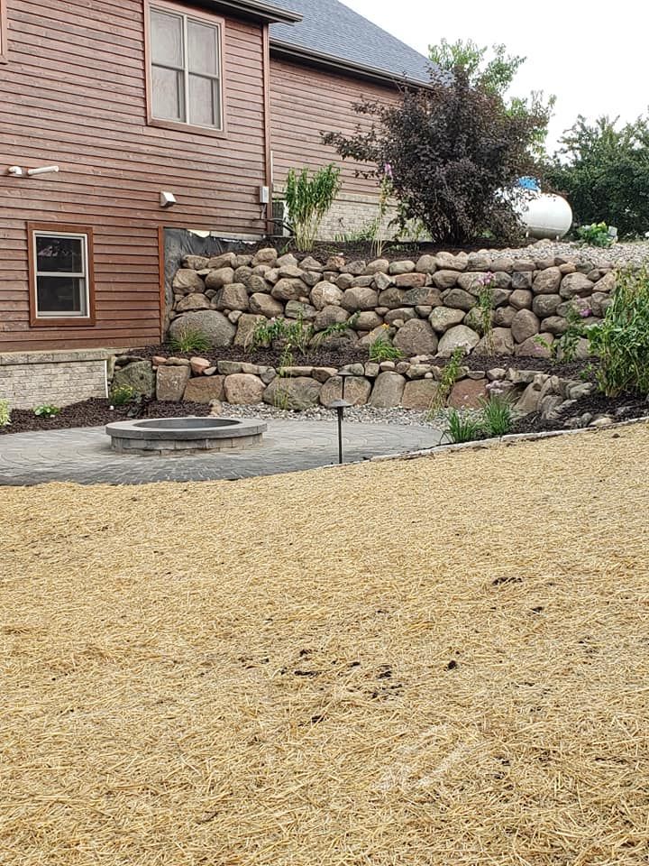 there is a large rock wall in the backyard of a house .