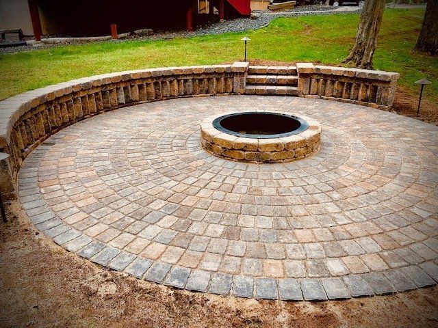 a fire pit is surrounded by bricks on a patio .