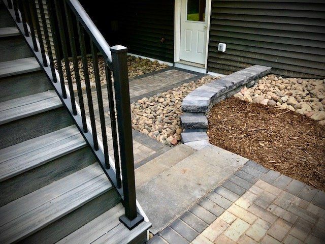 a set of stairs leading up to a house with a black railing .