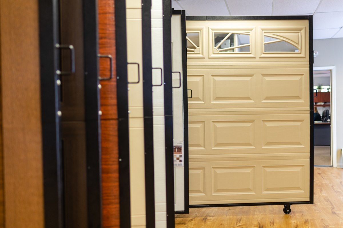 Garage door samples in a showroom, showing various styles and colors.