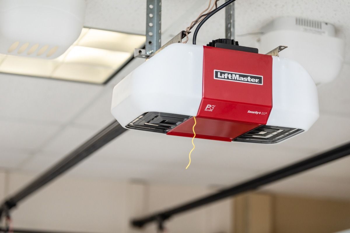 A red and white LiftMaster garage door opener mounted on a white ceiling.