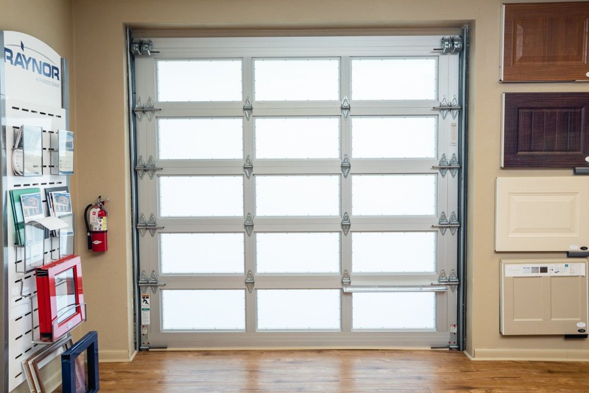 Glass garage door with frosted panels; displayed in a showroom setting.