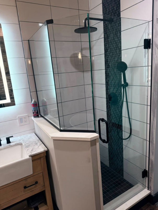 A bathroom with a walk in shower and a sink.