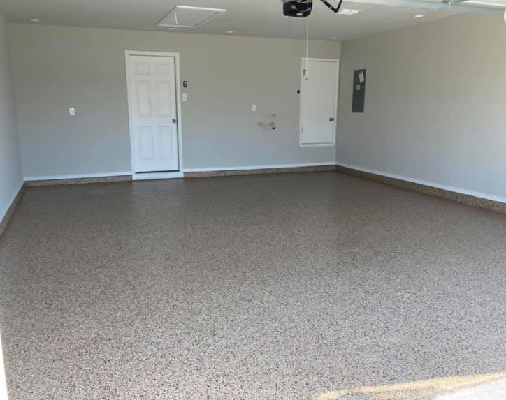 Empty garage with epoxy floor, white doors, and gray walls.
