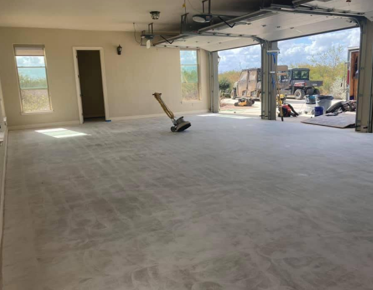 Open garage door with construction equipment visible.