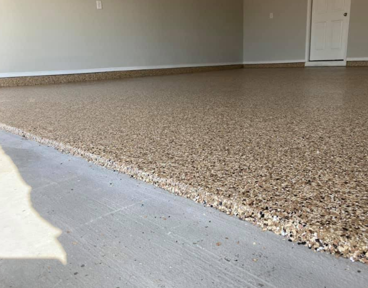 Garage floor with speckled epoxy coating in shades of tan and brown.