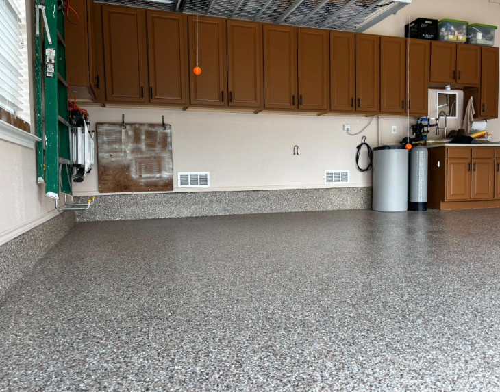 Garage interior with epoxy flooring, brown cabinets, and water filtration system.