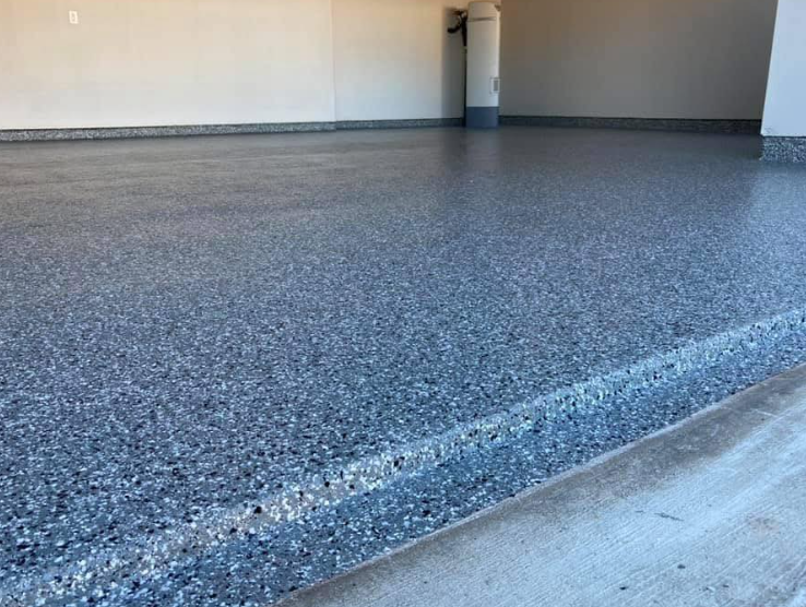 A freshly coated garage floor with dark blue and gray flecks reflecting light.