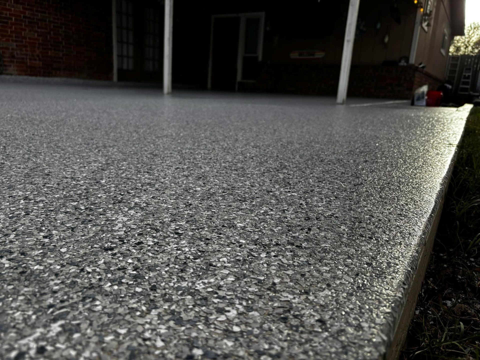 A close-up view of a gray speckled epoxy patio surface.