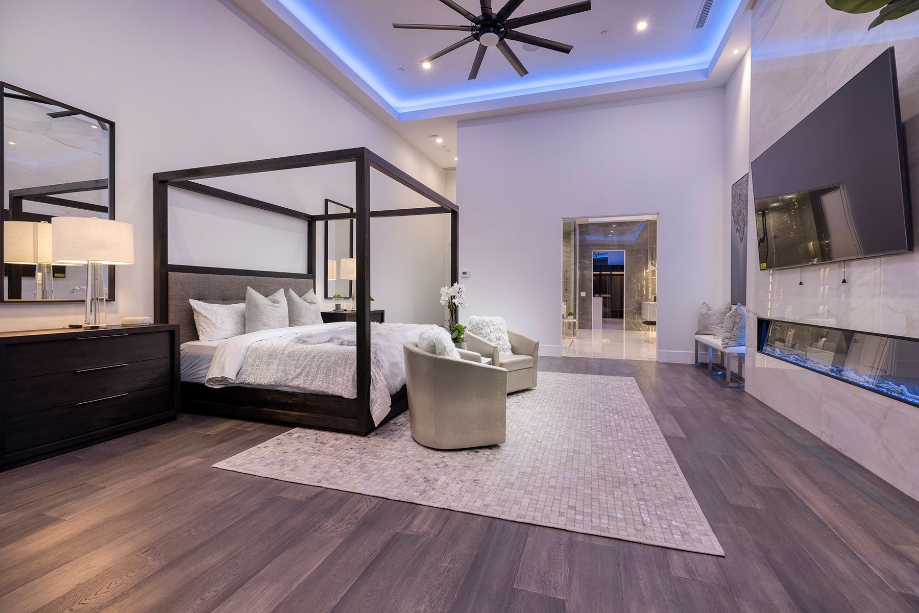 A bedroom with a canopy bed and a fireplace.