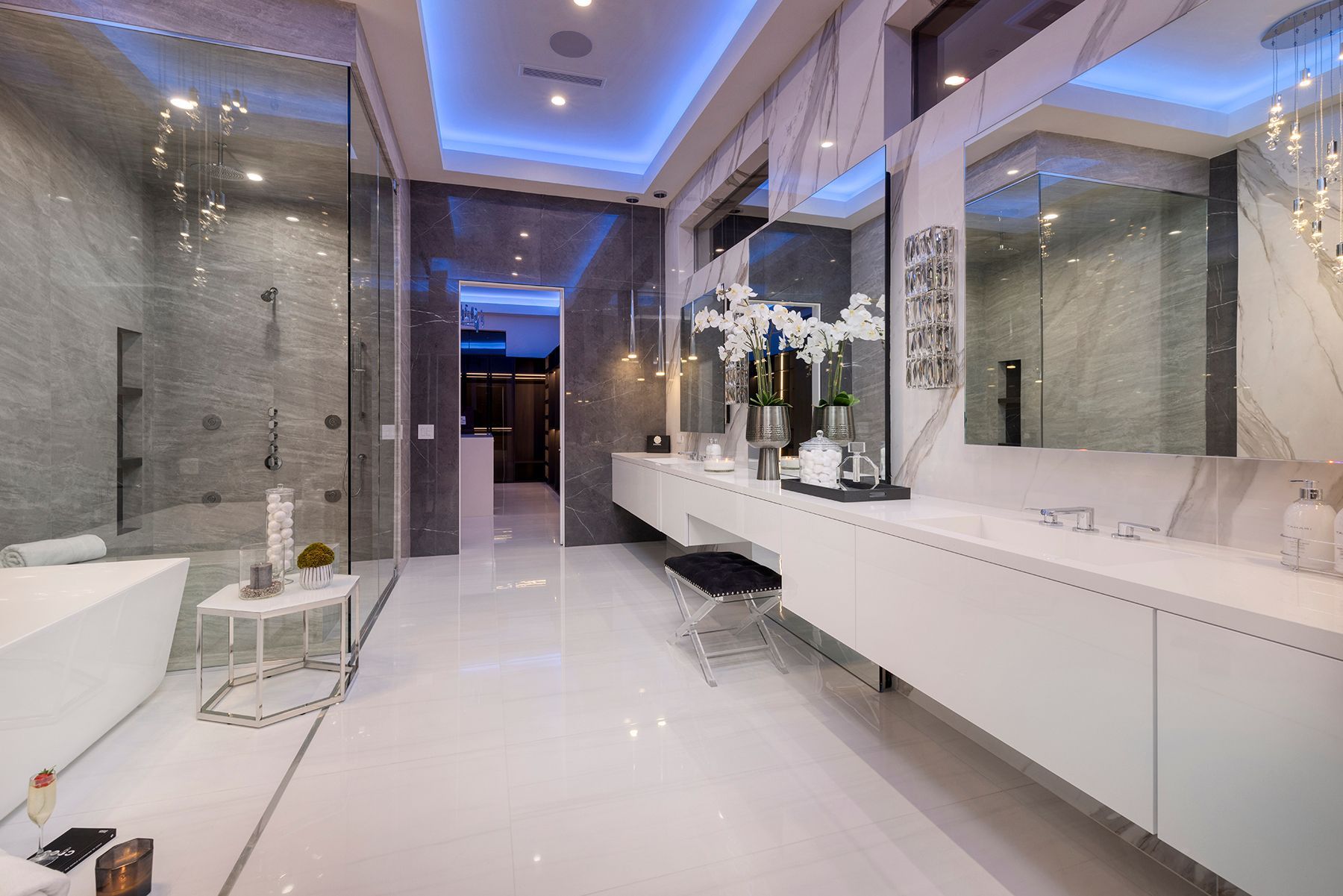 A bathroom with a bathtub, sinks, mirrors, and a walk-in shower.