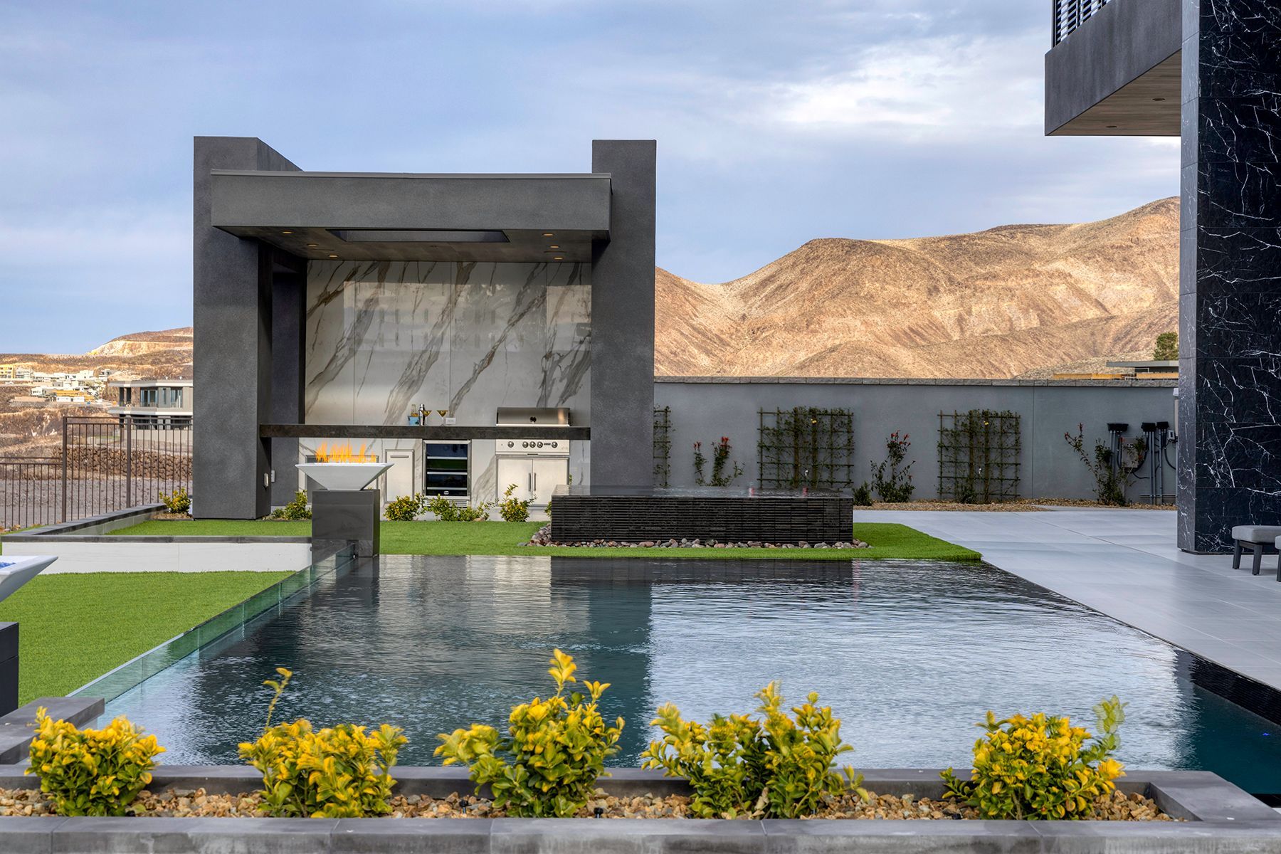 A modern house with a large swimming pool in front of it.