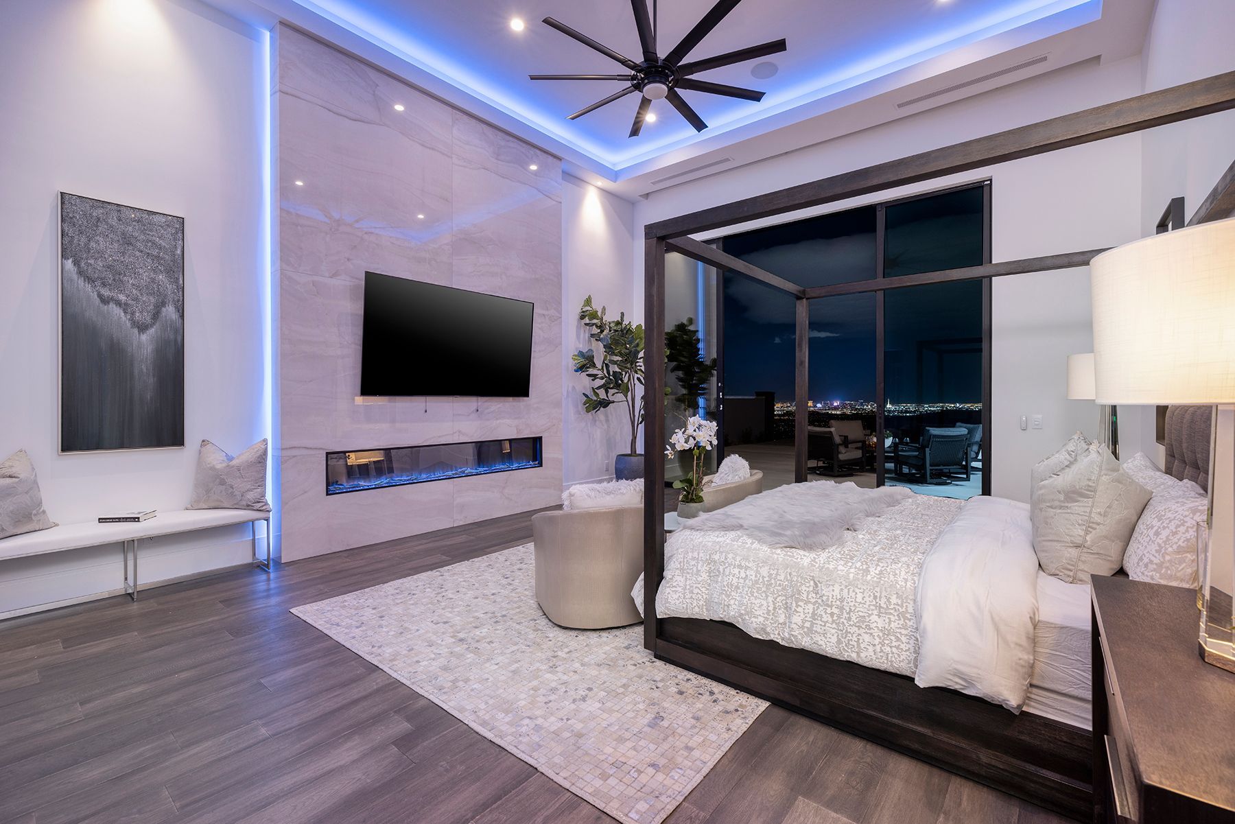 A bedroom with a canopy bed and a flat-screen tv.