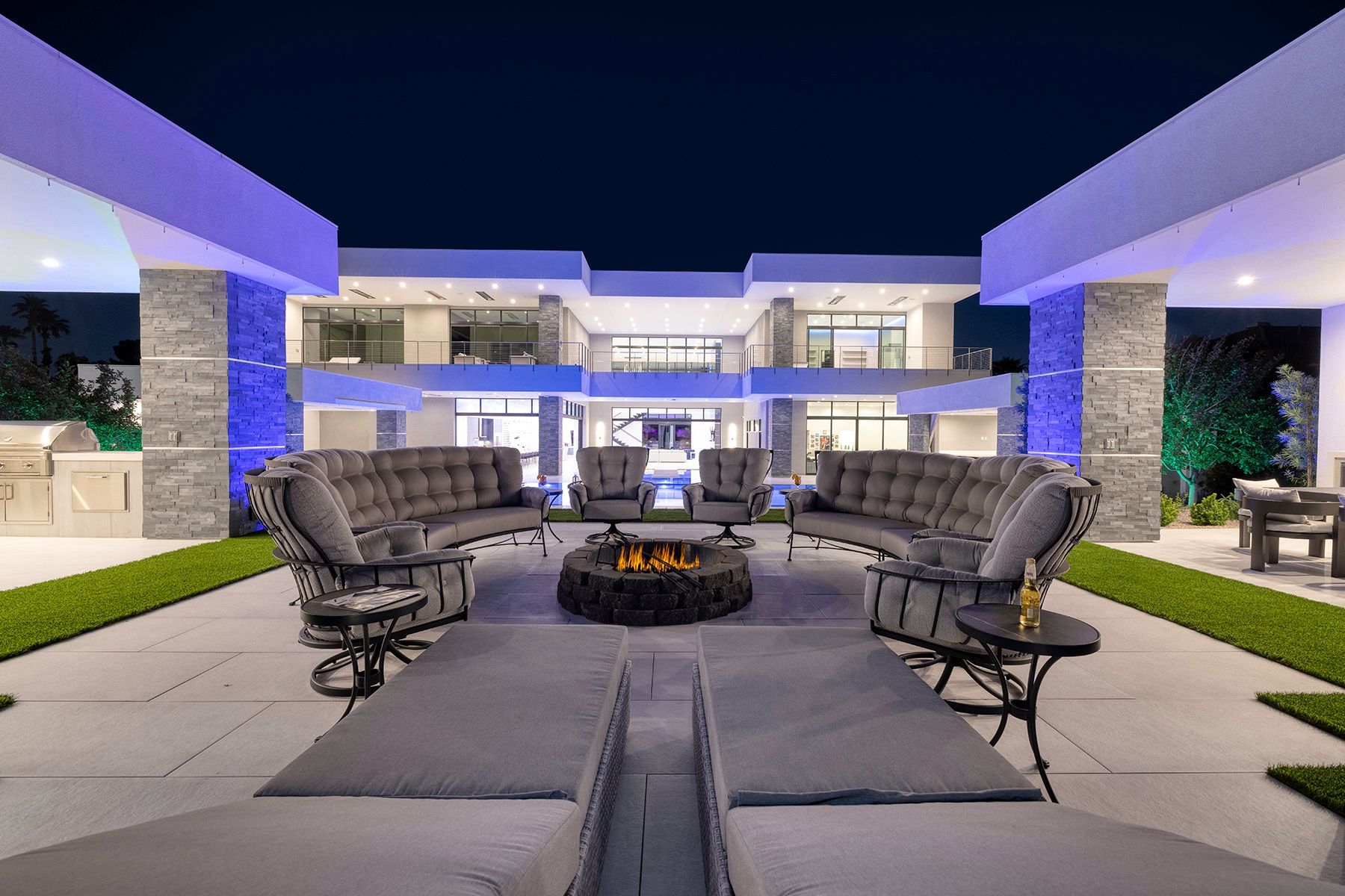 There is a fire pit in the middle of the courtyard of a large house.