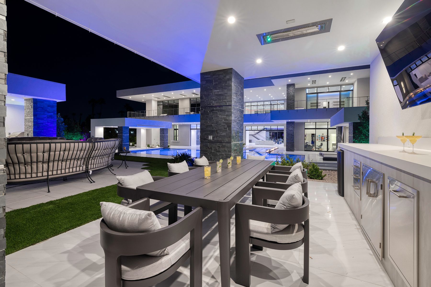 There is a table and chairs in the backyard of a house.