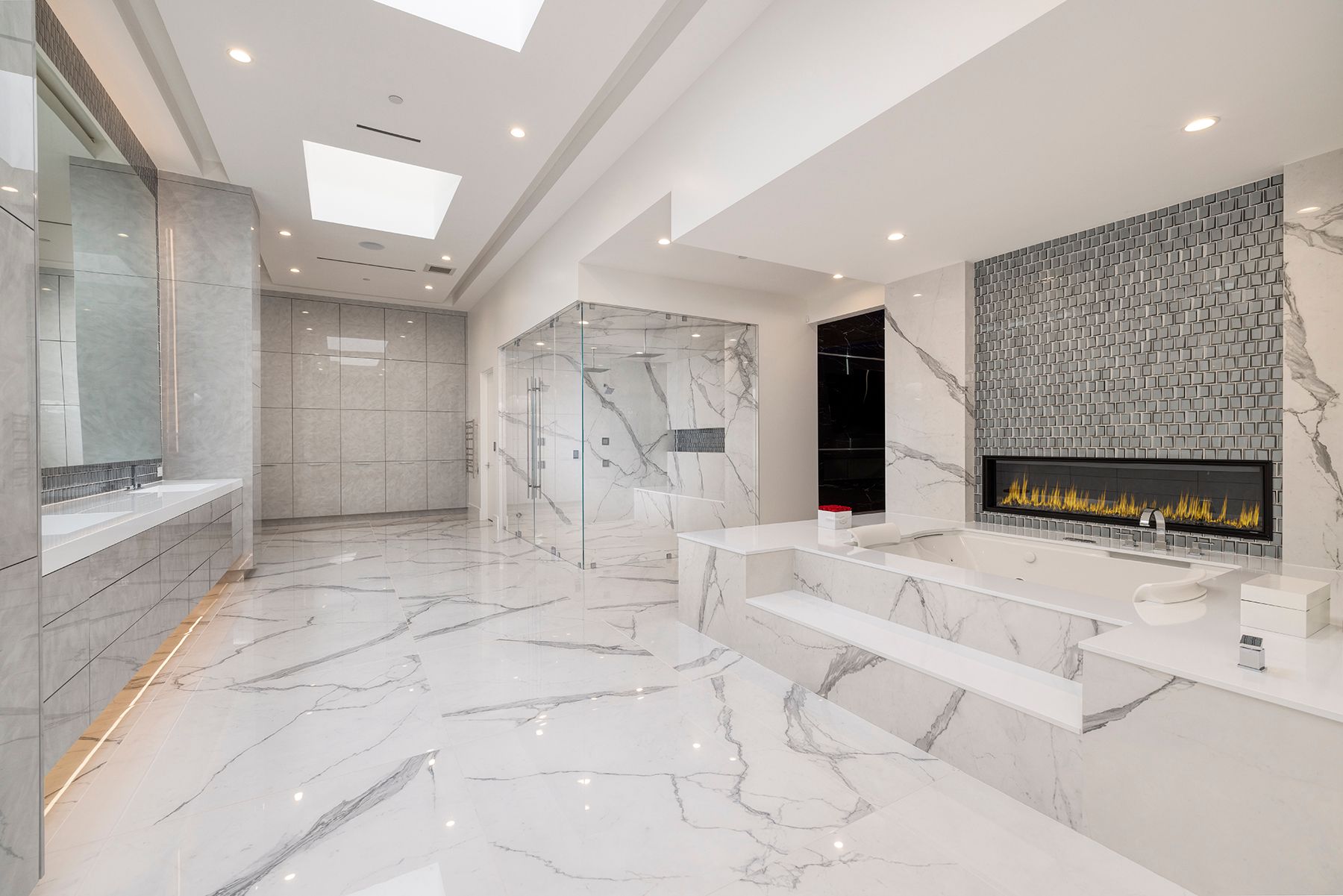 A large bathroom with marble floors and a fireplace.