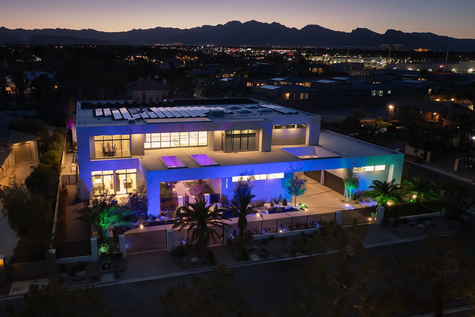An aerial view of a large house lit up at night.