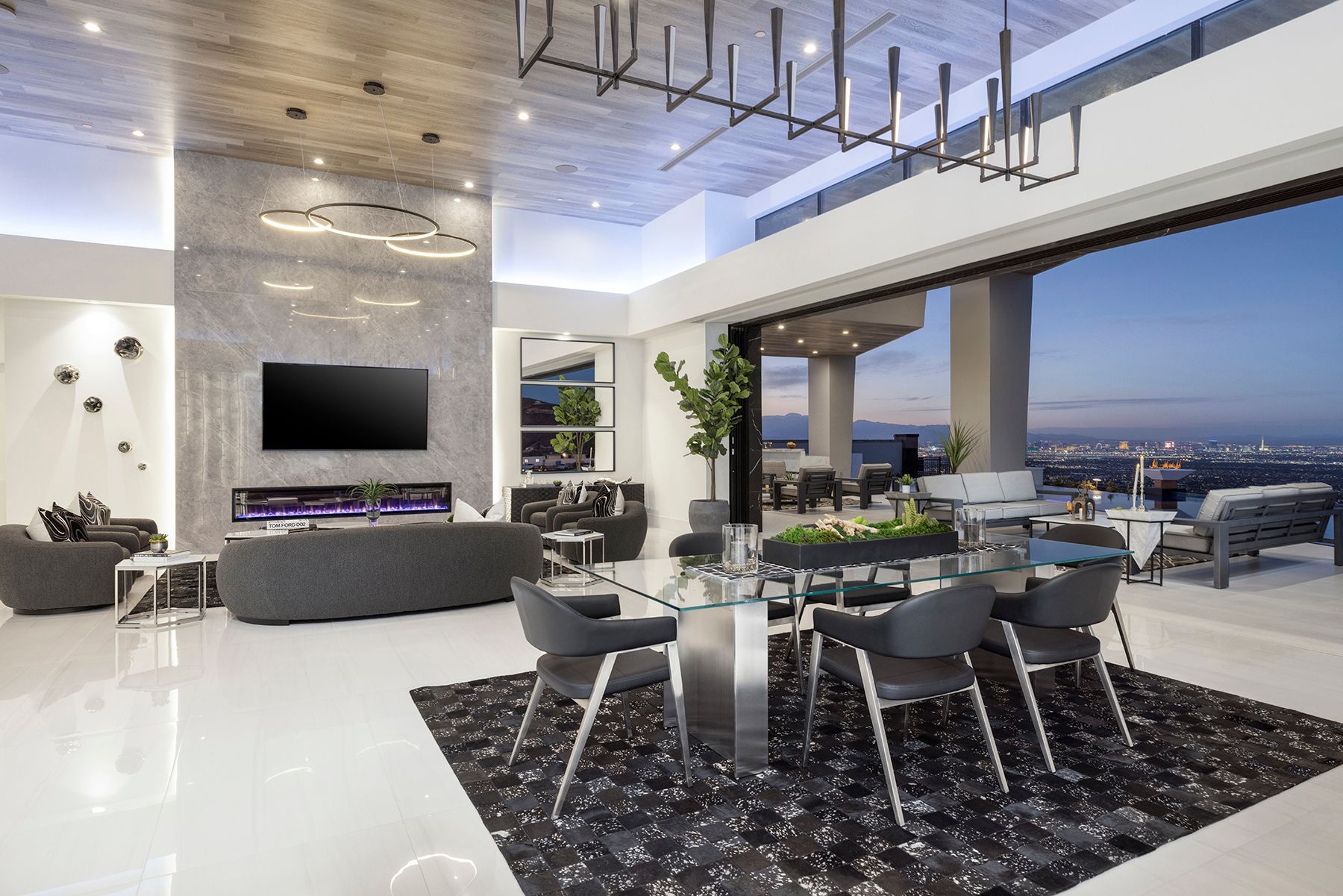 a living room with a dining table and chairs and a flat screen tv