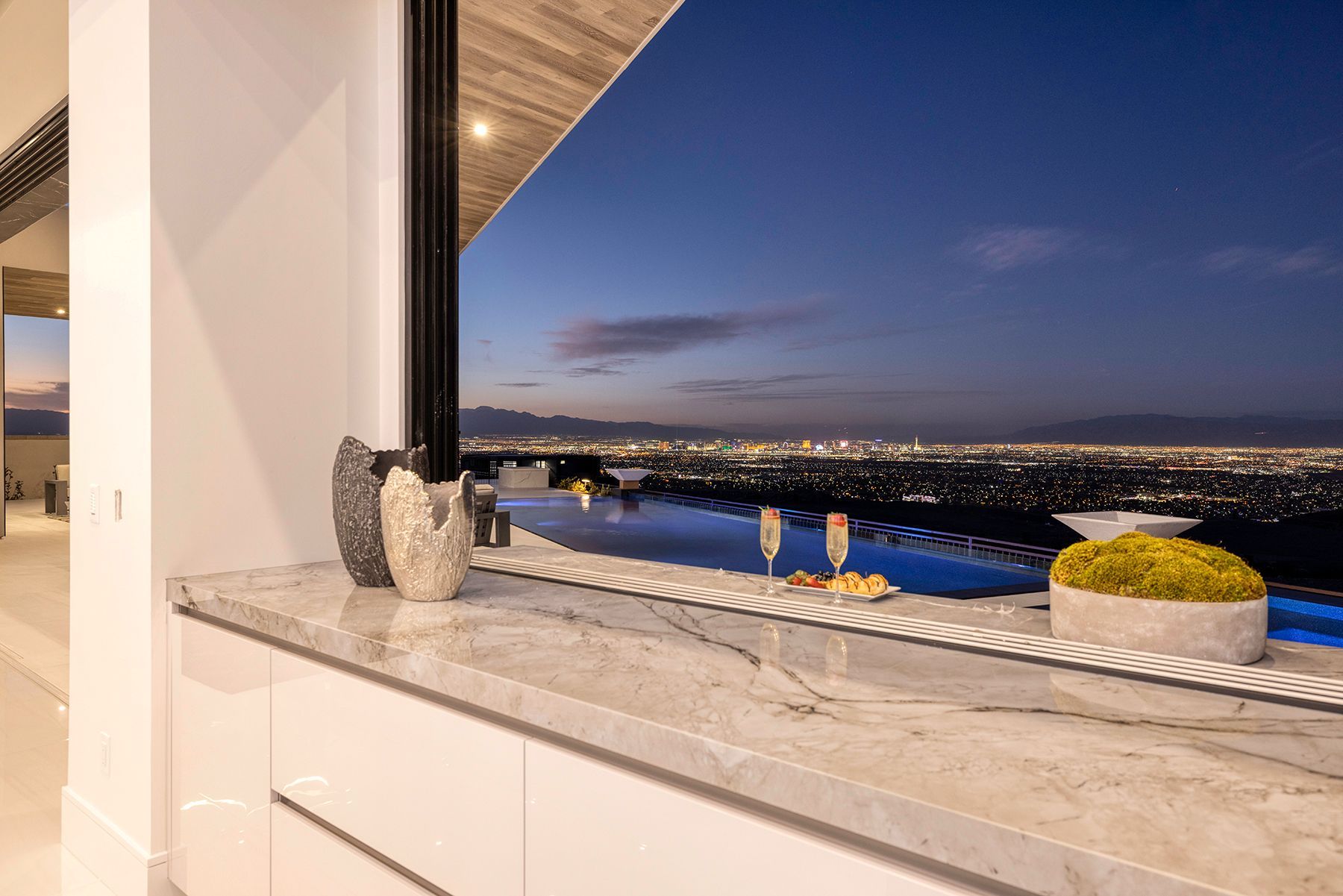 a kitchen counter with a view of the city and a swimming pool