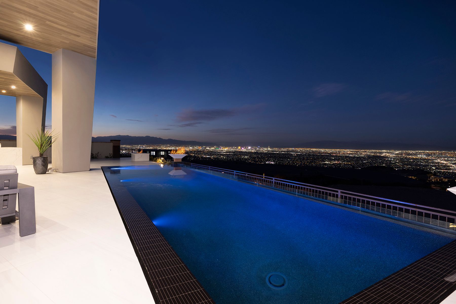 a large swimming pool with a view of the city at night