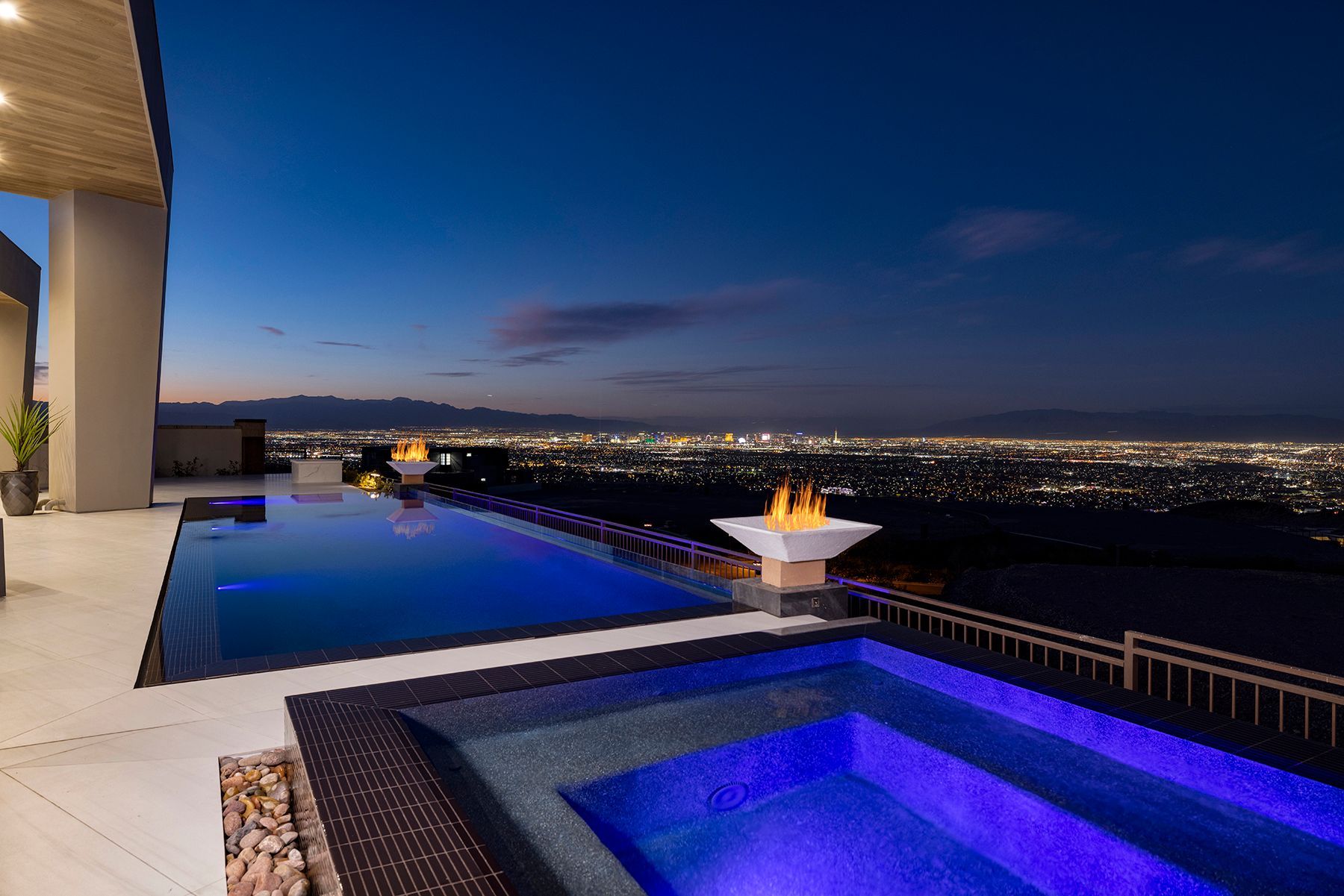 a large swimming pool with a view of the city at night