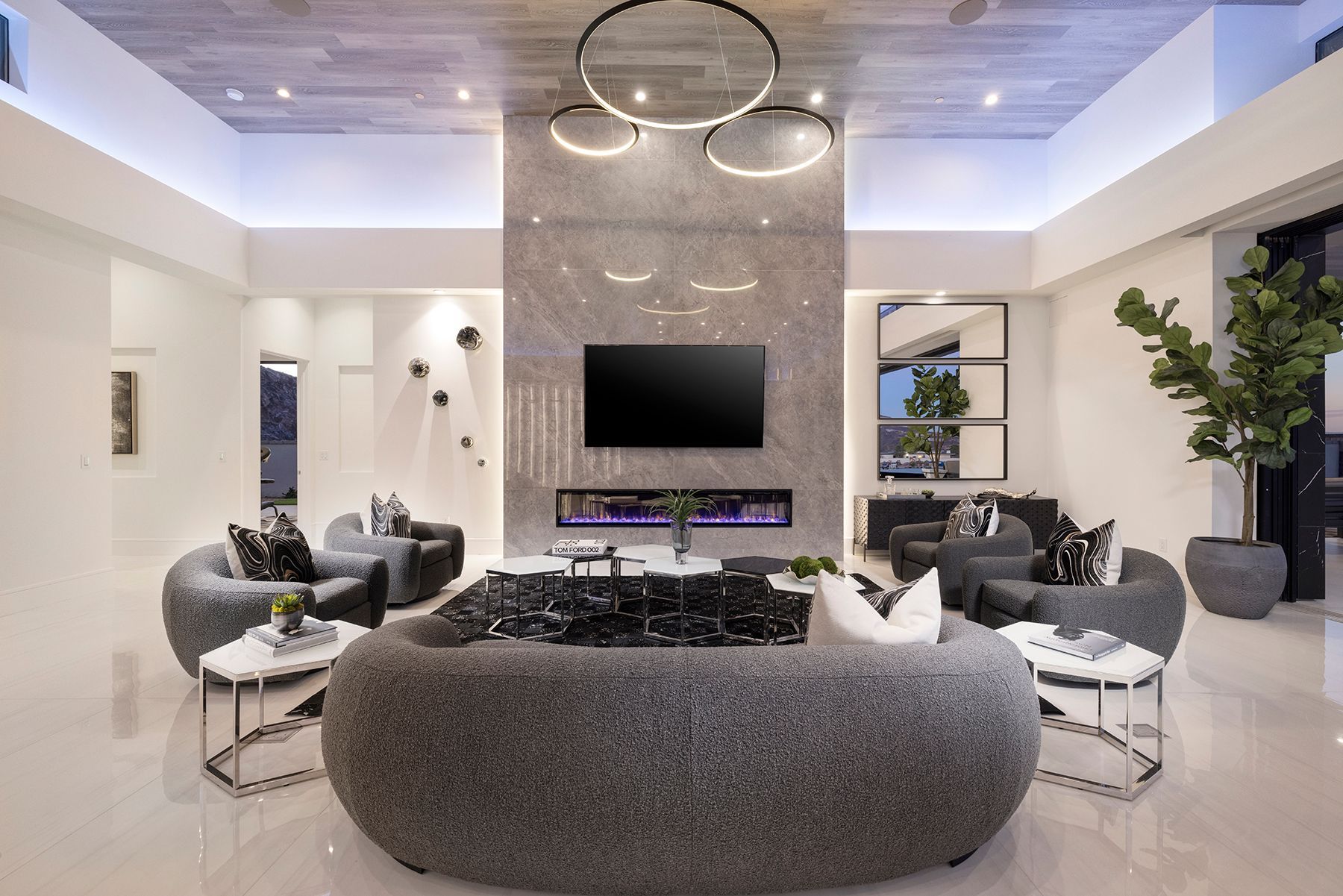 a living room with a couch, chairs, tables, and a flat screen tv 