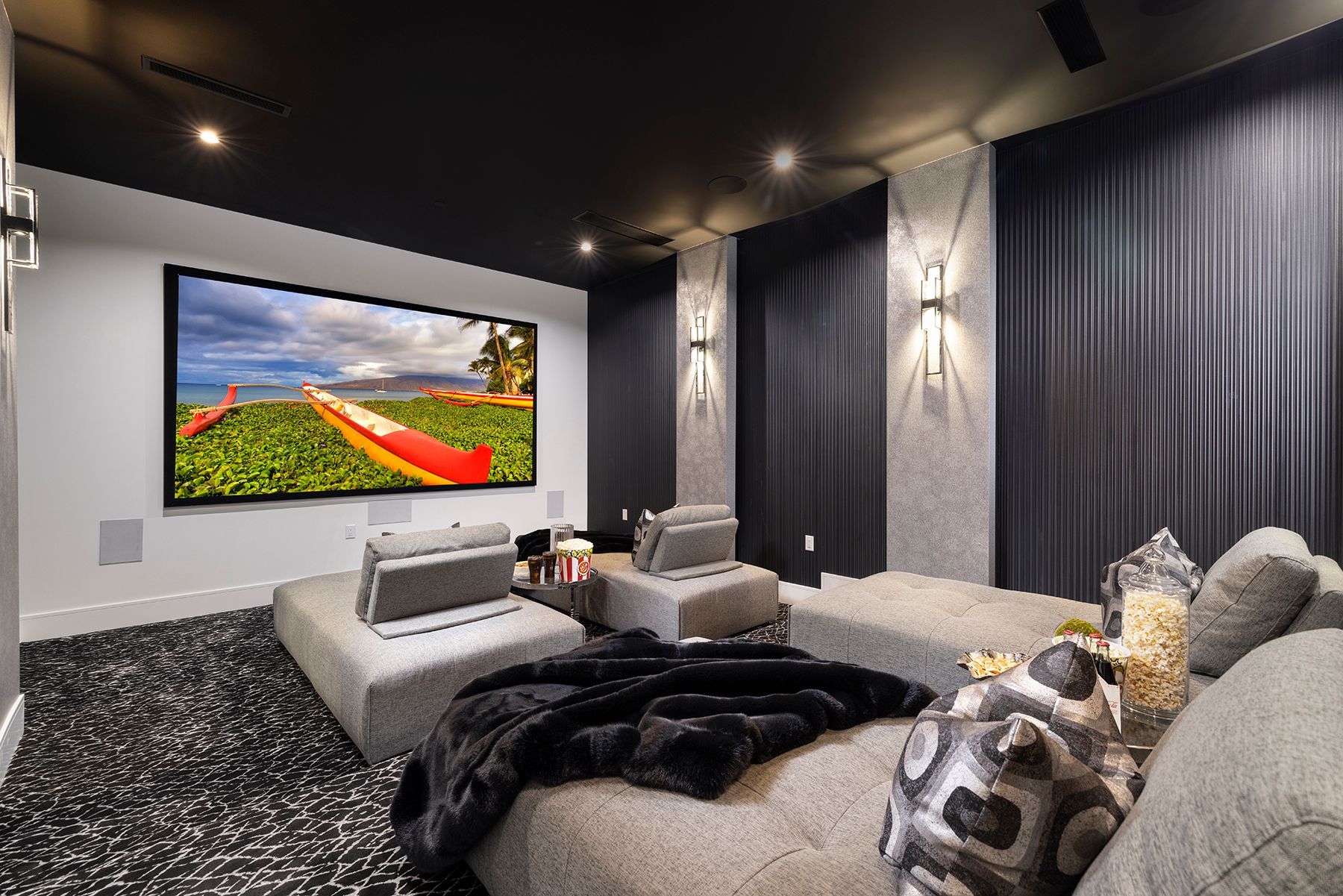 a home theater with a large flat screen tv on the wall