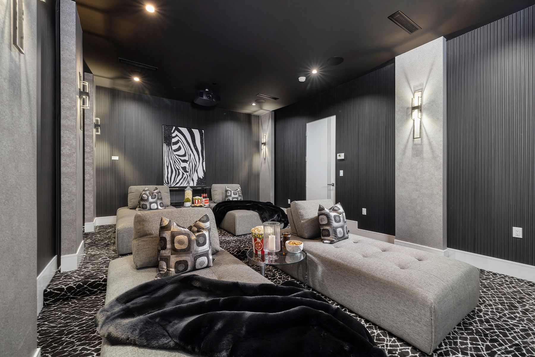 a home theater with a lot of furniture and a projector screen