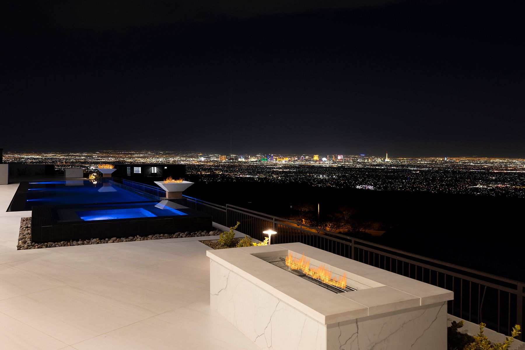 there is a fire pit on the patio with a view of the city at night