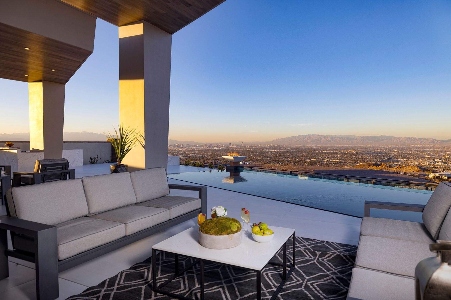 there is a couch and a table on the patio with a view of the city