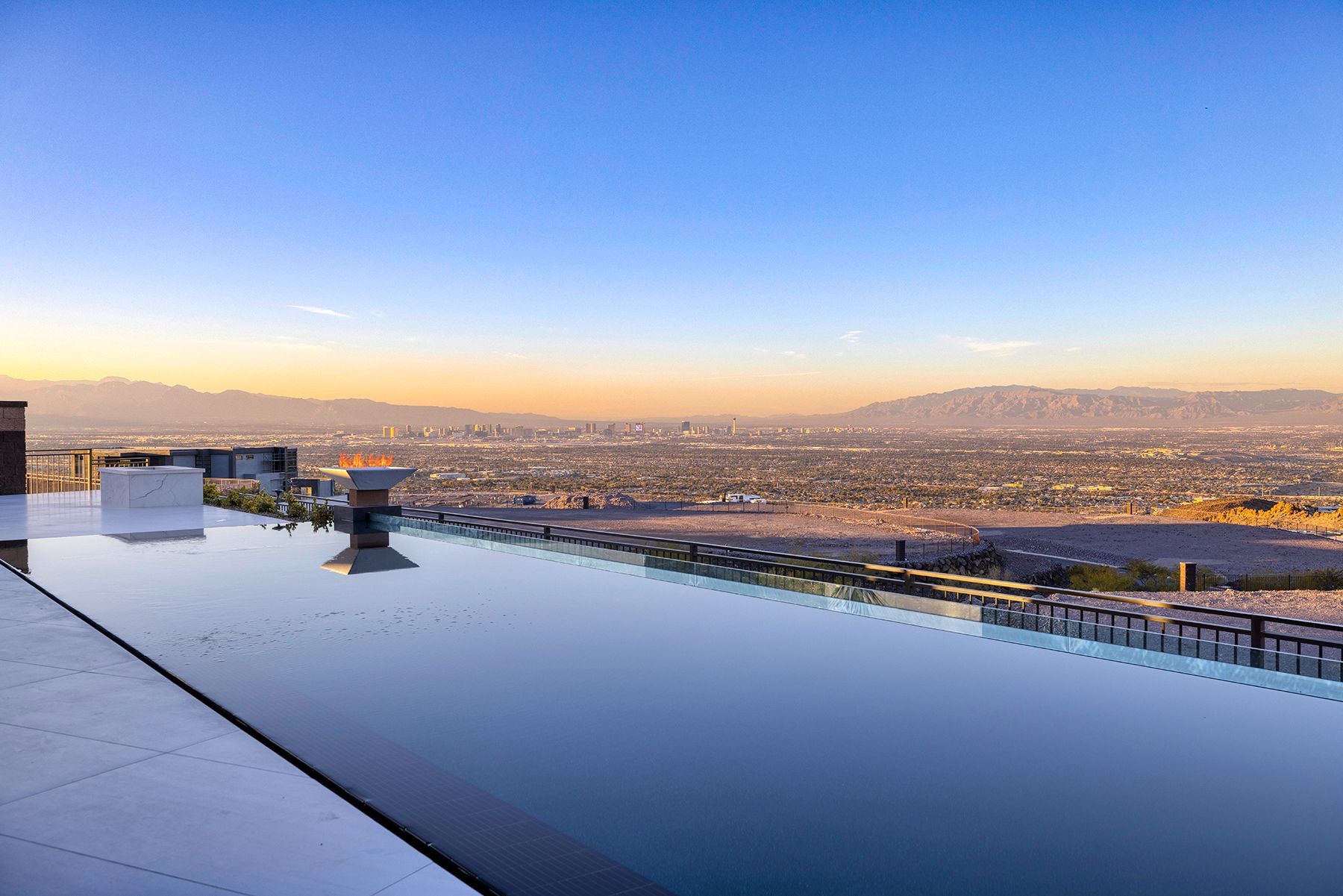 an infinity pool with a view of the city and mountains