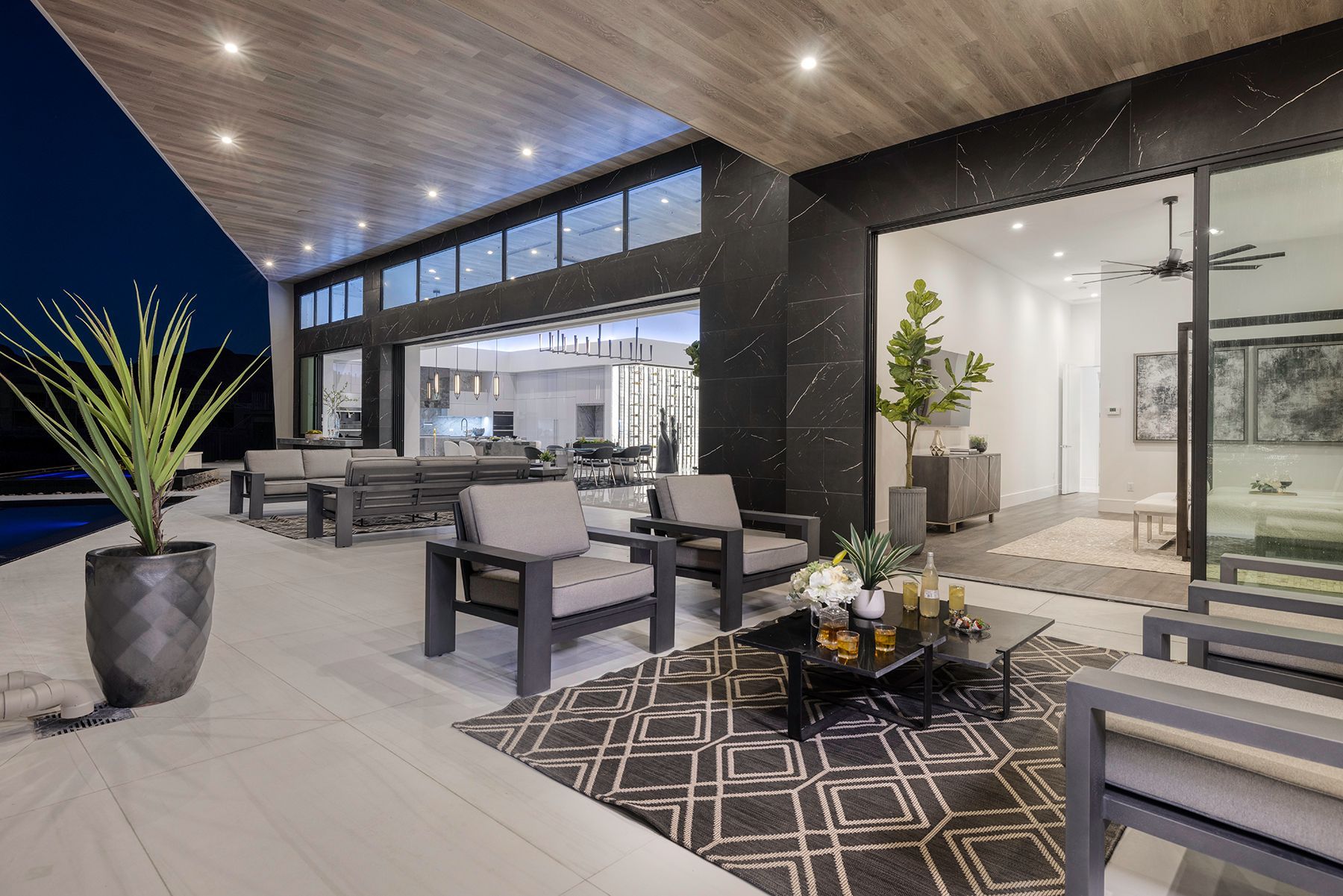 a patio with chairs, a table, and a potted plant