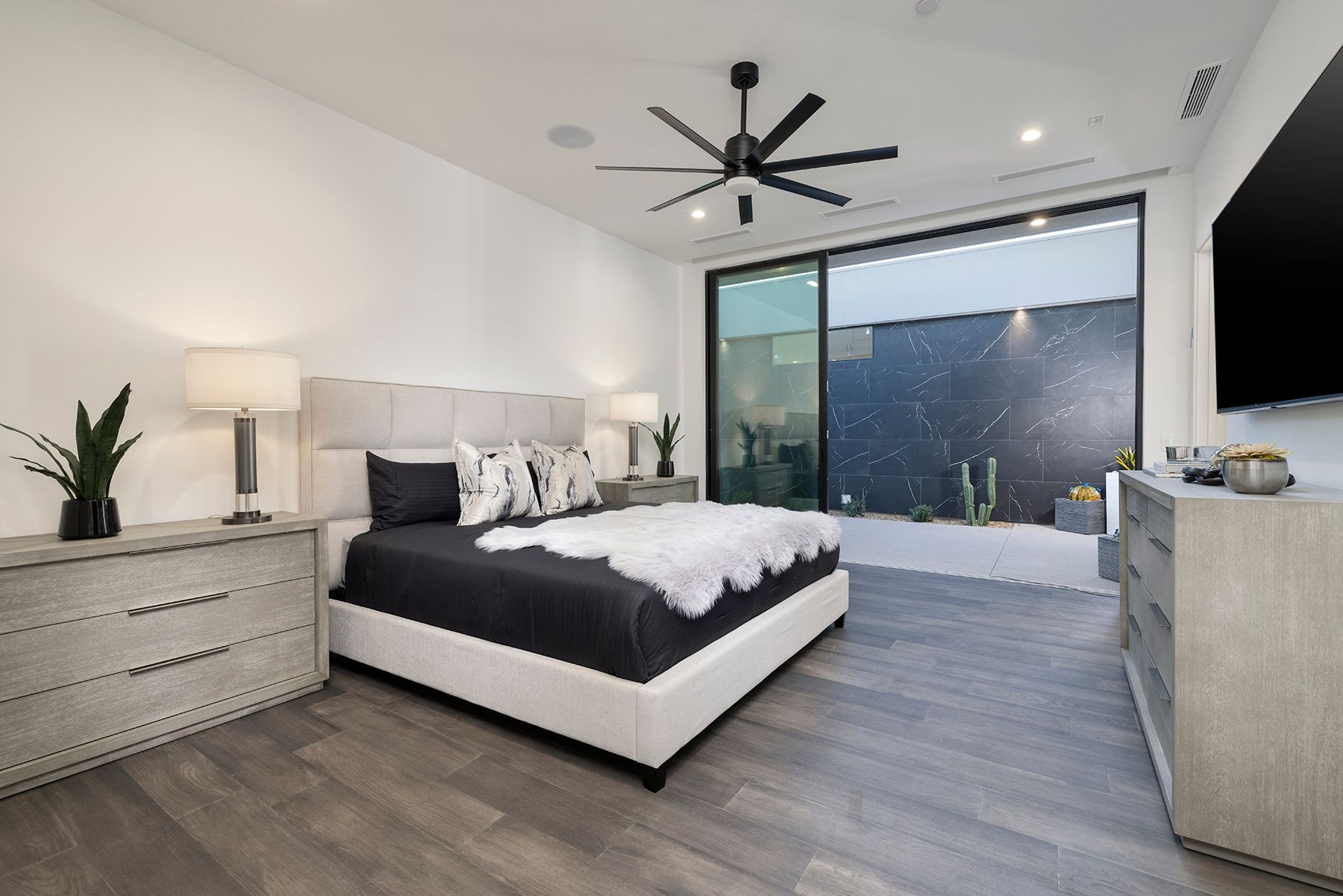a bedroom with a large bed and a ceiling fan
