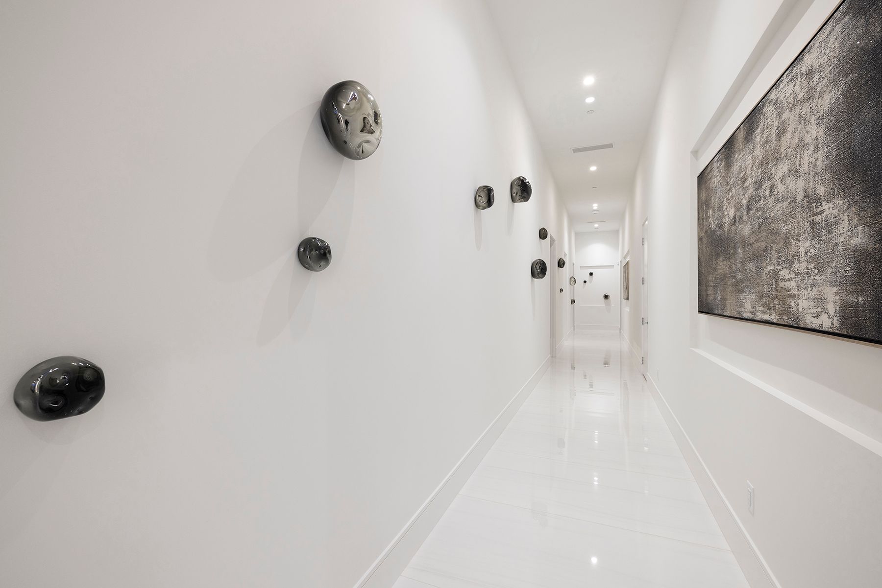 a long white hallway with a painting on the wall