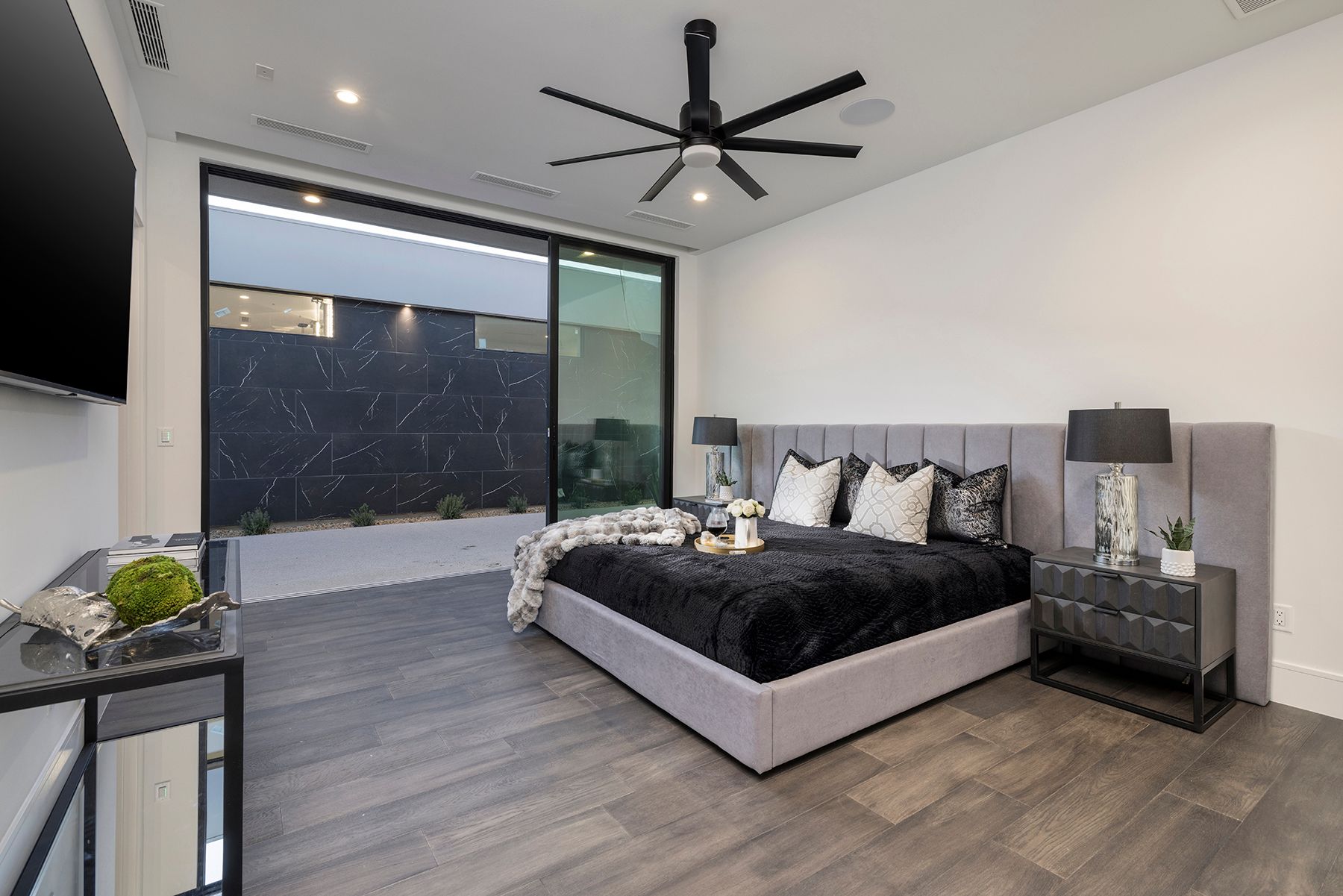 a bedroom with a large bed and a ceiling fan