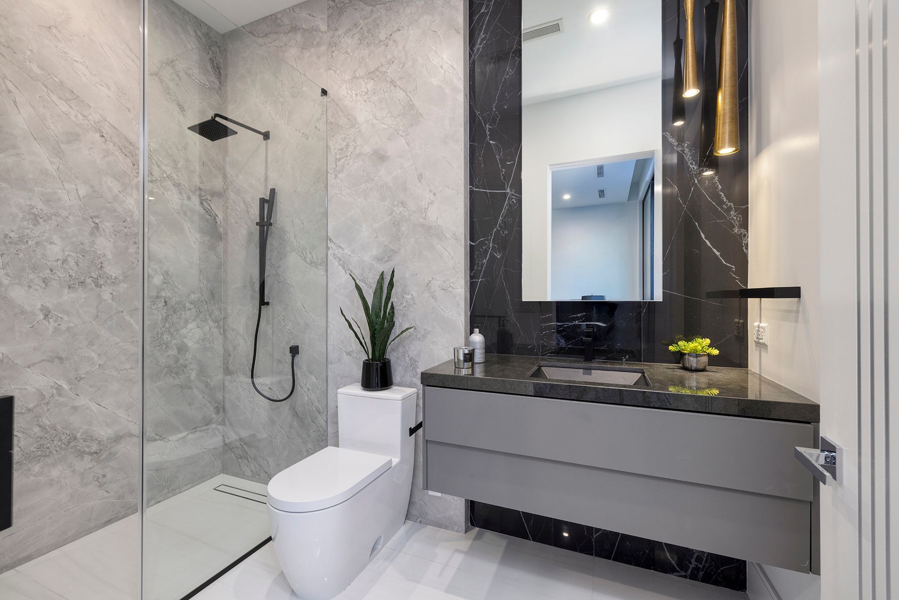 a bathroom with a toilet, sink, shower and mirror