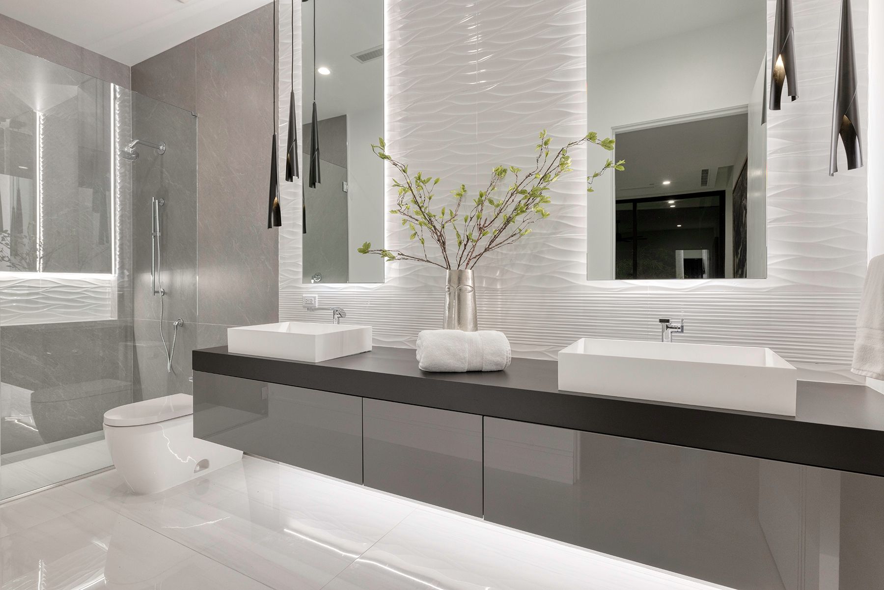 a bathroom with two sinks, a toilet, and two mirrors