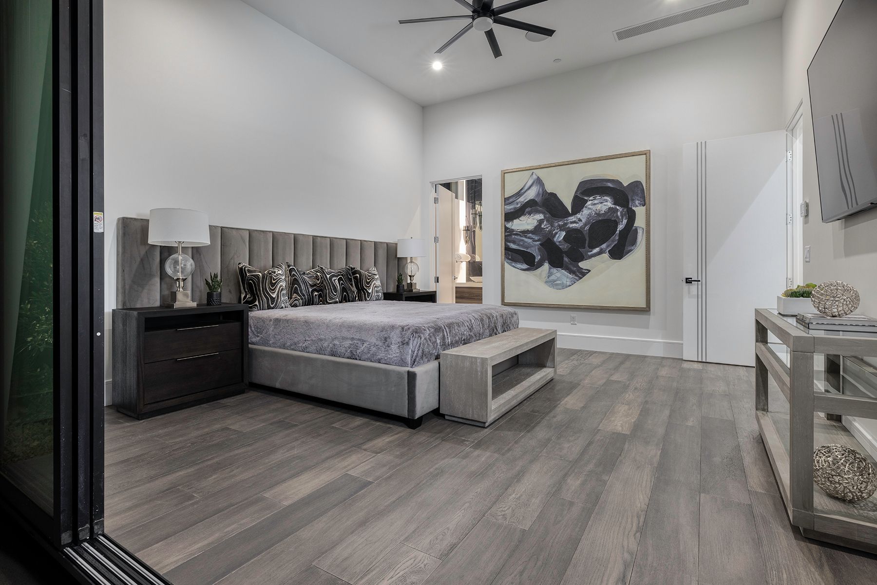 a bedroom with a large bed and a painting on the wall