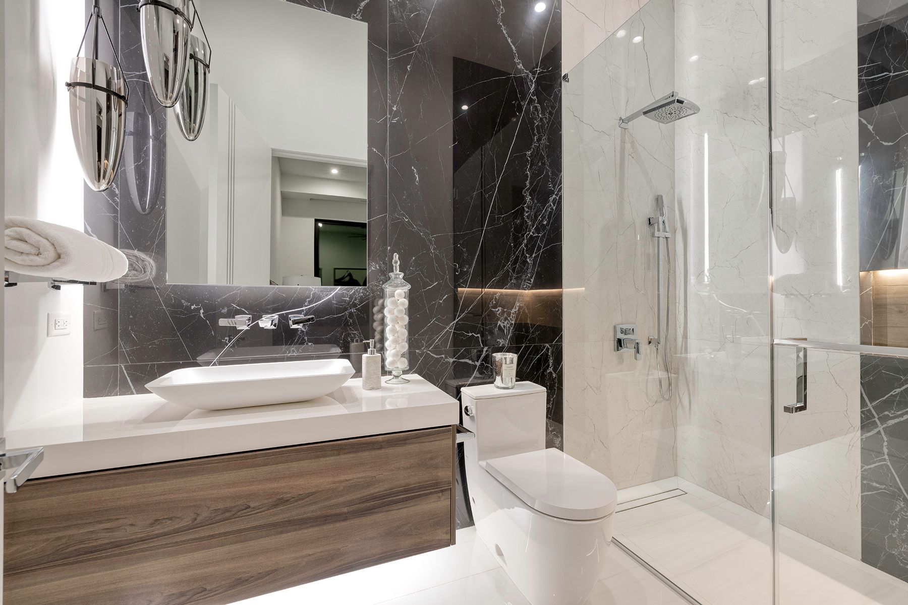 a bathroom with a toilet, sink, mirror and walk-in shower