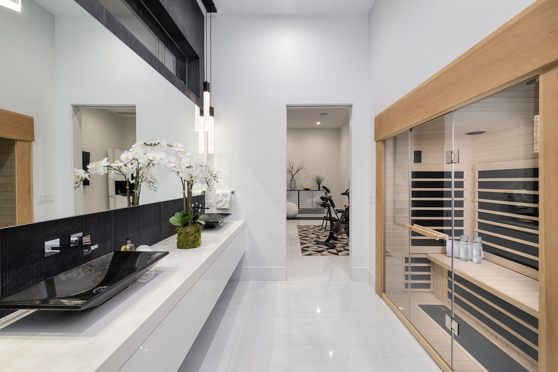 a bathroom with a sink, mirror, and sauna