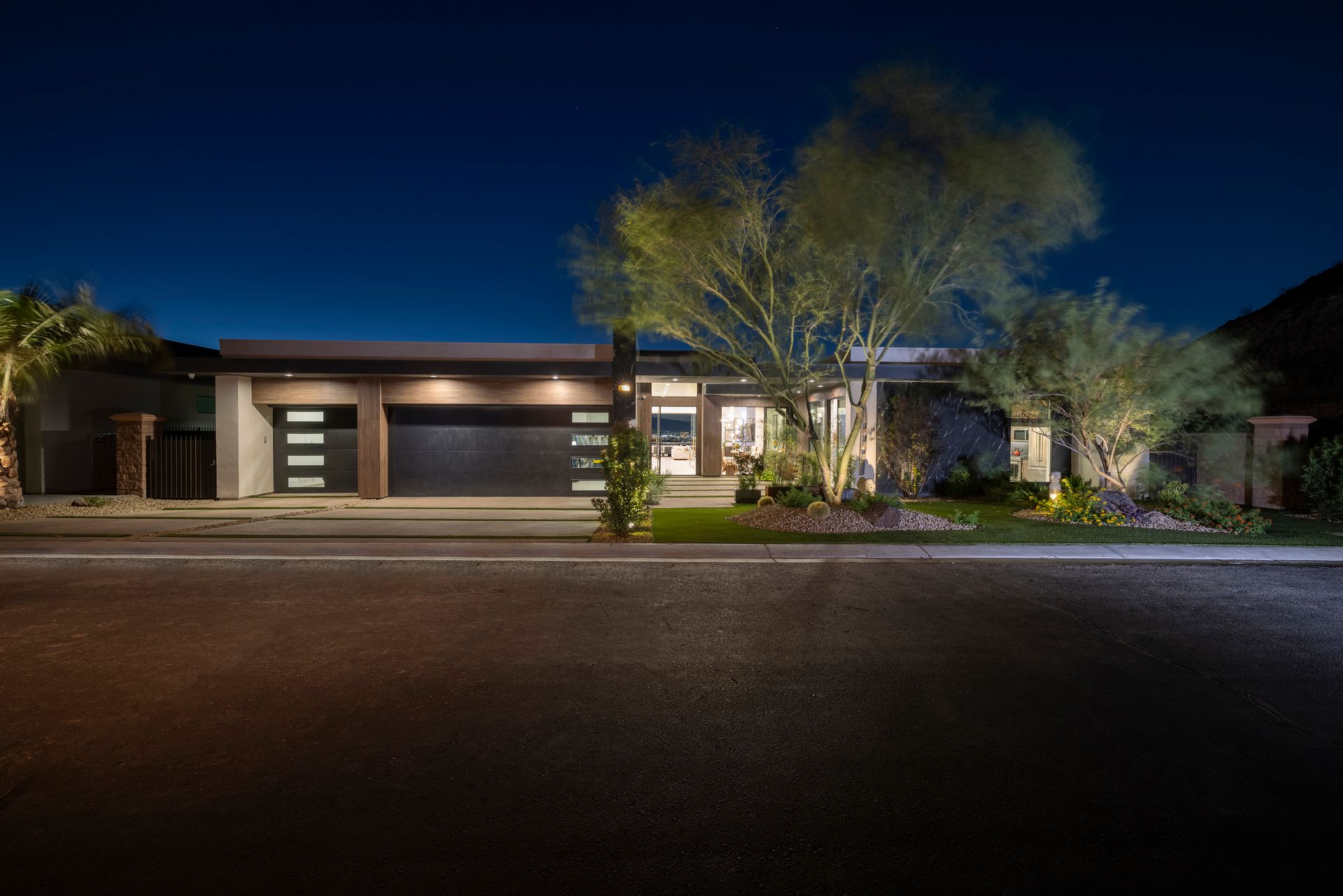 A contemporary residence illuminated at night, showcasing its warm glow through well-lit windows.