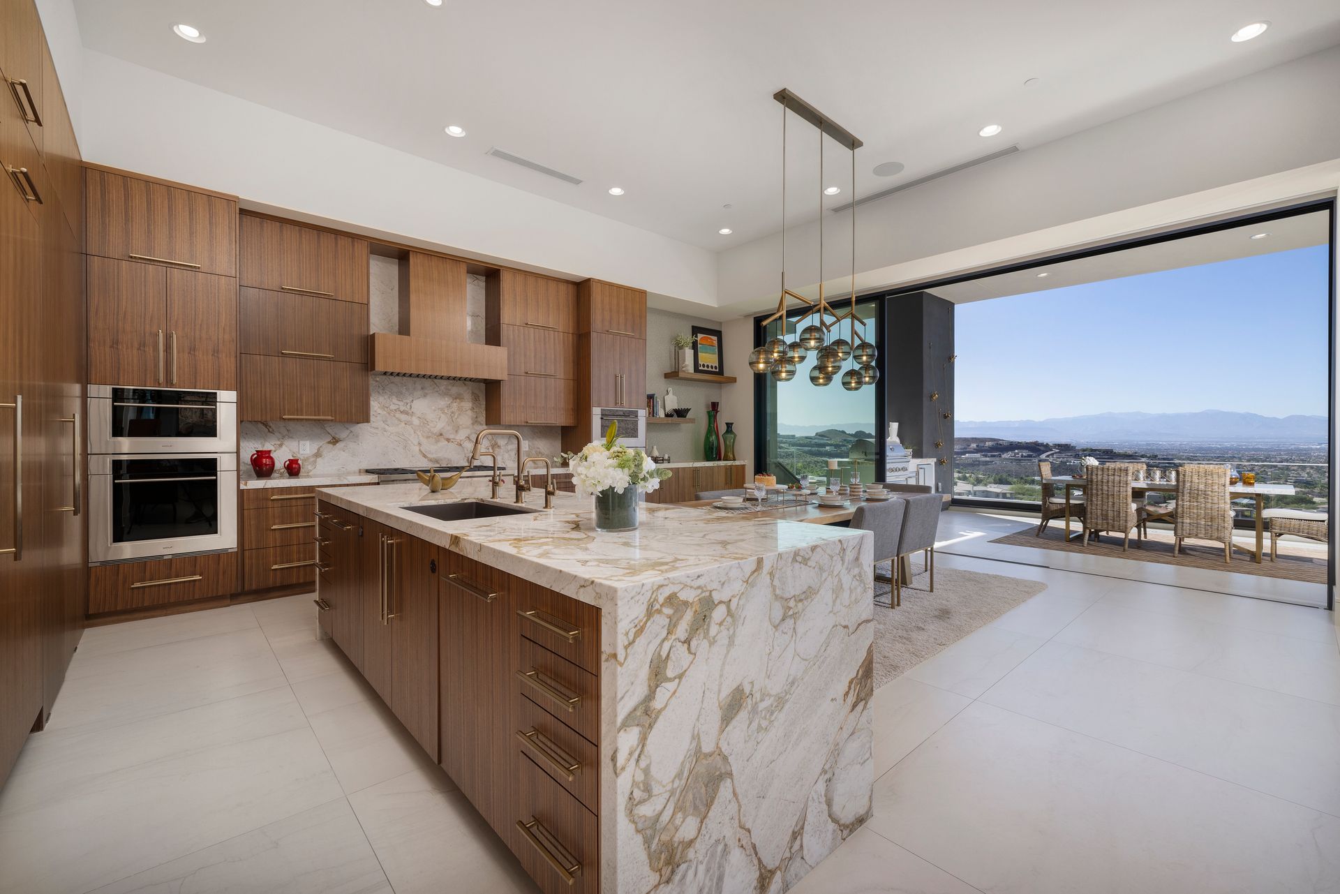 An elegant kitchen boasting a generous marble island and a stunning outlook.