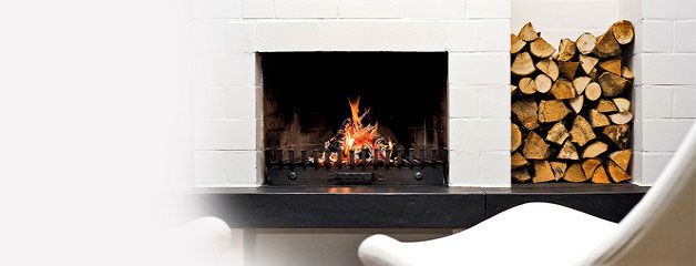 A modern fireplace with firewood beside it